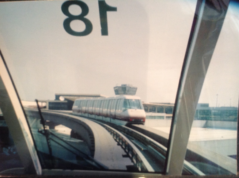 [New York]The picture taken from the front of a Monorail train passing another shows the  Airtrain monorail linking Newark Airport to the main line interchange station. It was cutting edge technology when opened in 2000. Kids love it, regular users have probably got over the novelty. It is slow, wobbly and unreliable and the airport is out to render for a replacement system similar to that at JFK Airport. Each compartment is separate, with a door, akin to a slam door suburban carriage, however the doors slide open automatically. The operation is completely automatic with very loud safety warnings.  Photo by Ian Brown for Railfuture
